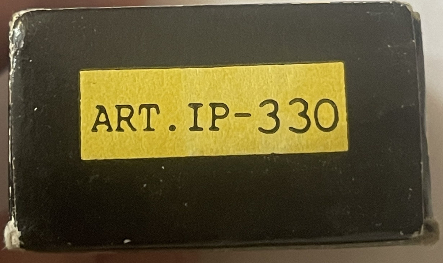 Black box with yellow label reading "ART.IP-330" centered on cover