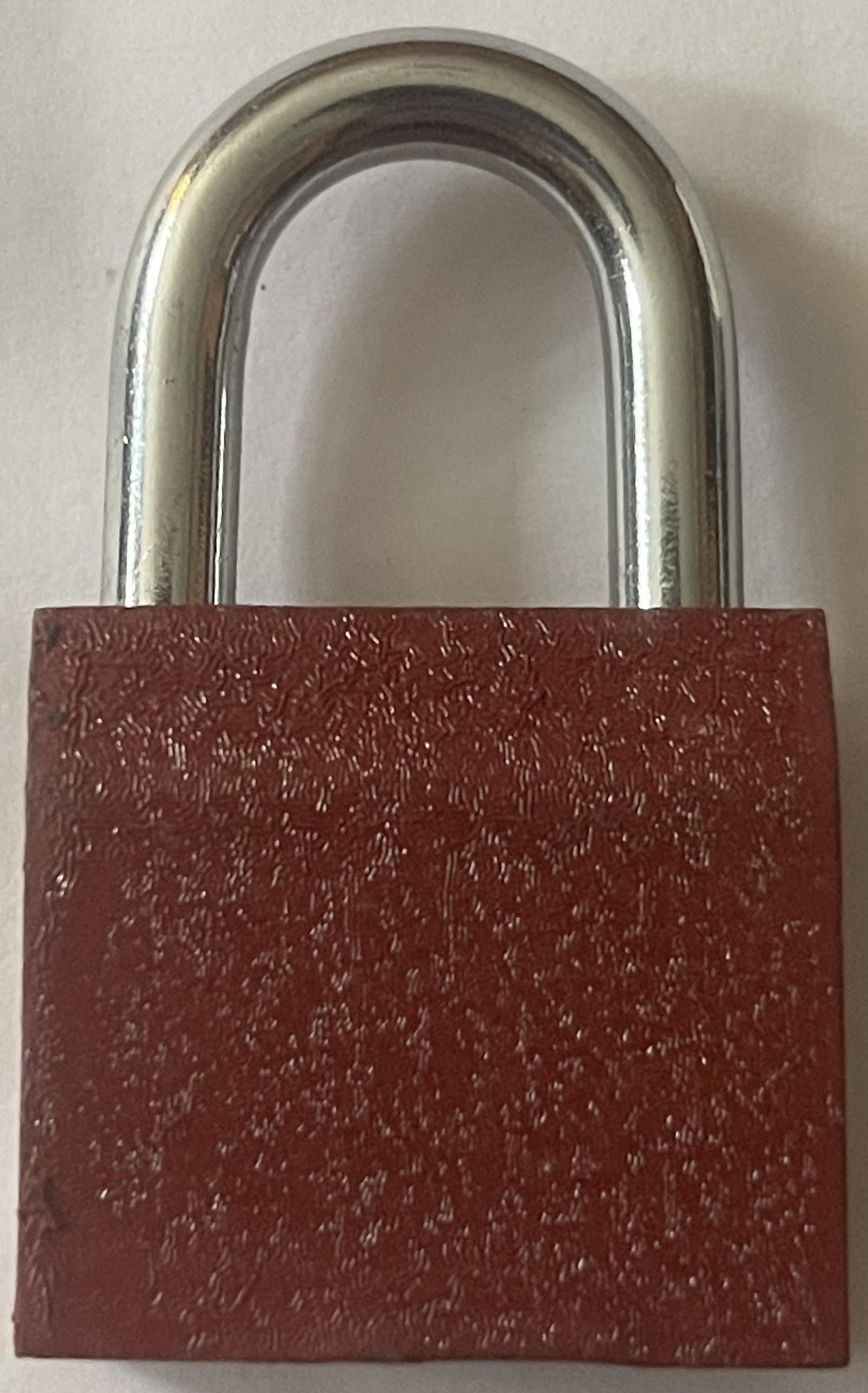 Vintage padlock with silver metal U-shaped shackle and deep red textured body against white background