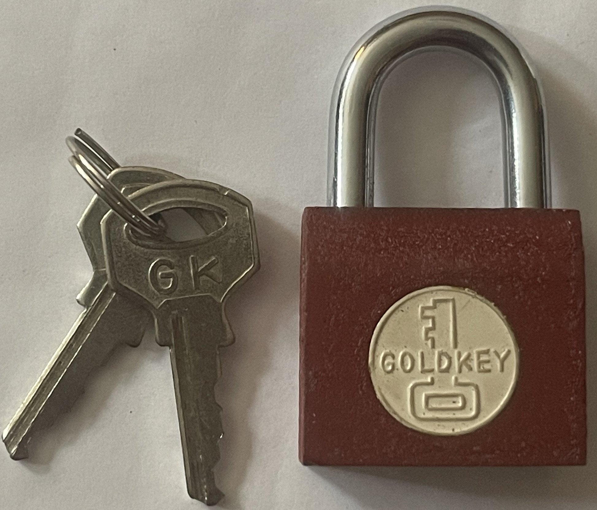 Vintage GoldKey padlock with burgundy body and chrome shackle, displayed next to two silver keys marked "GK