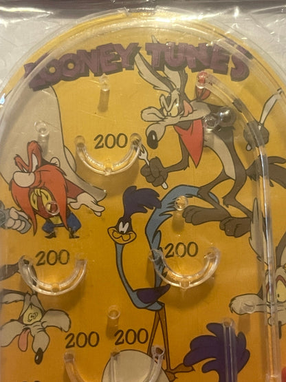 Amber-colored mini pinball playfield with Looney Tunes characters including Bugs Bunny, Wile E Coyote, and Road Runner, marke