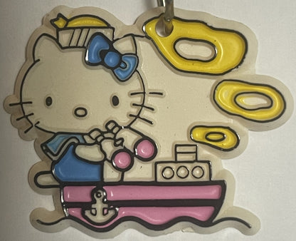 Vintage Hello Kitty sailor boat keychain with blue bow and pink boat, yellow life preserver details, cream-colored plastic, o