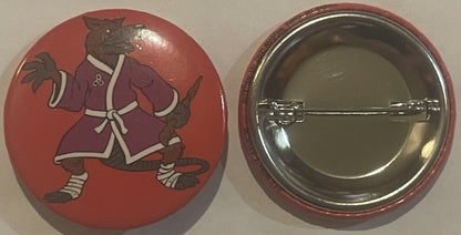 Front and back of red circular pinback button featuring brown cartoon rat character in purple robe with white trim