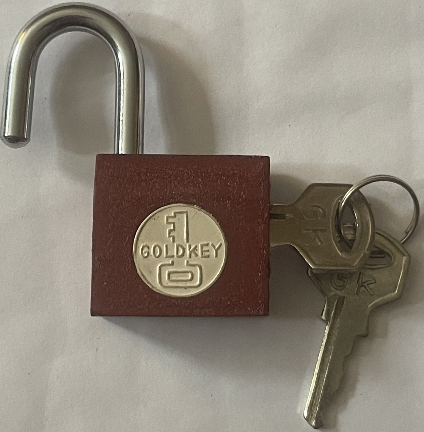 Vintage GoldKey padlock with burgundy body and chrome shackle, shown open with two brass keys beside it on white background