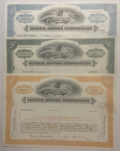 Three General Motors Corporation stock certificates from the 1950s-80s featuring streamlined locomotive vignettes, displayed 