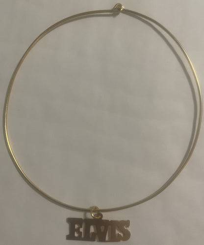 Gold-tone choker necklace with "ELVIS" nameplate charm pendant displayed flat against white background
