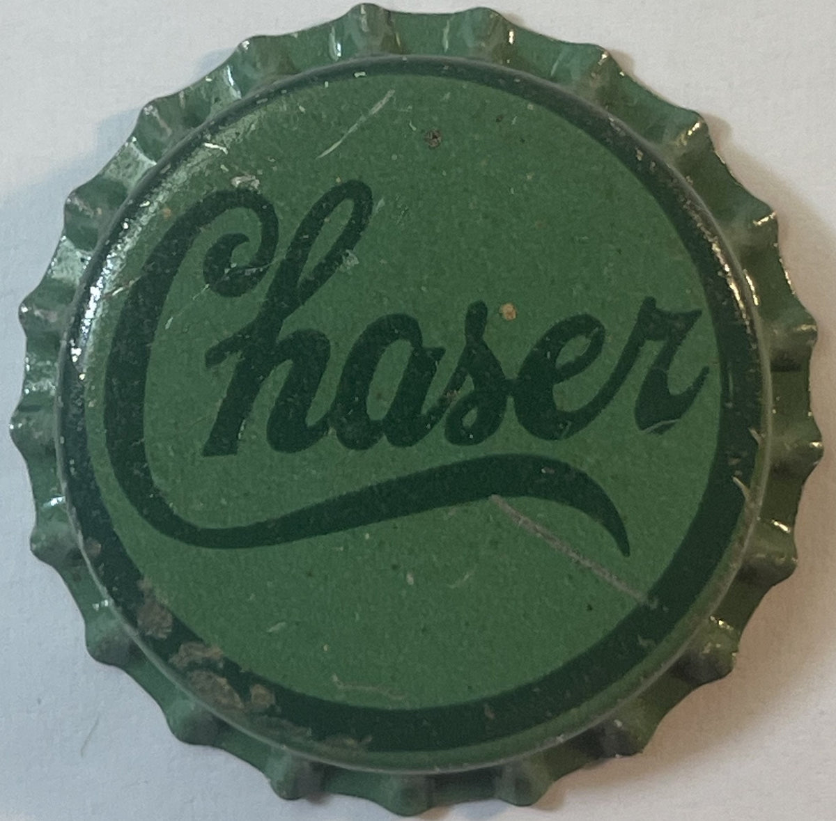 Chaser bottle cap: green crown with Chaser in dark green script and a long swash underline inside a dark green ring