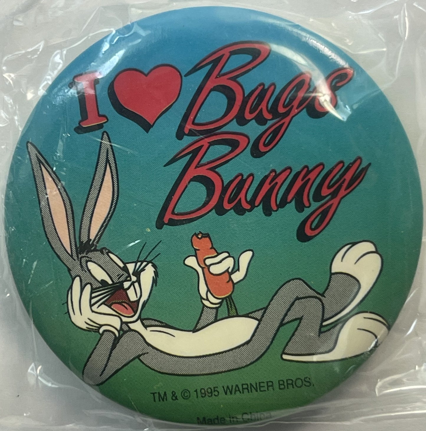 Circular pin in clear plastic packaging showing Bugs Bunny with "I ❤ Bugs Bunny" text on turquoise-to-green gradient backgrou