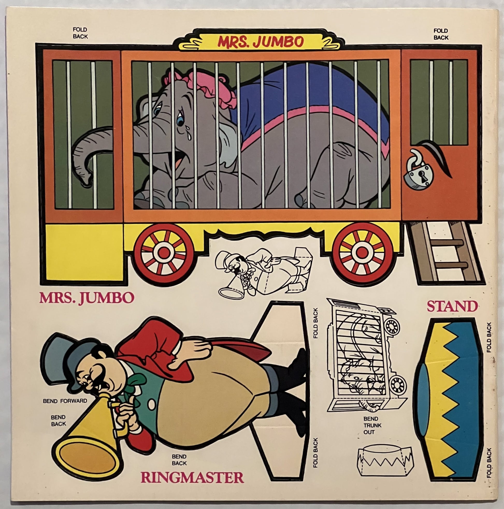 Unfolded vintage Dumbo press-out book page showing Mrs. Jumbo circus wagon, Ringmaster figure, and stand components with fold