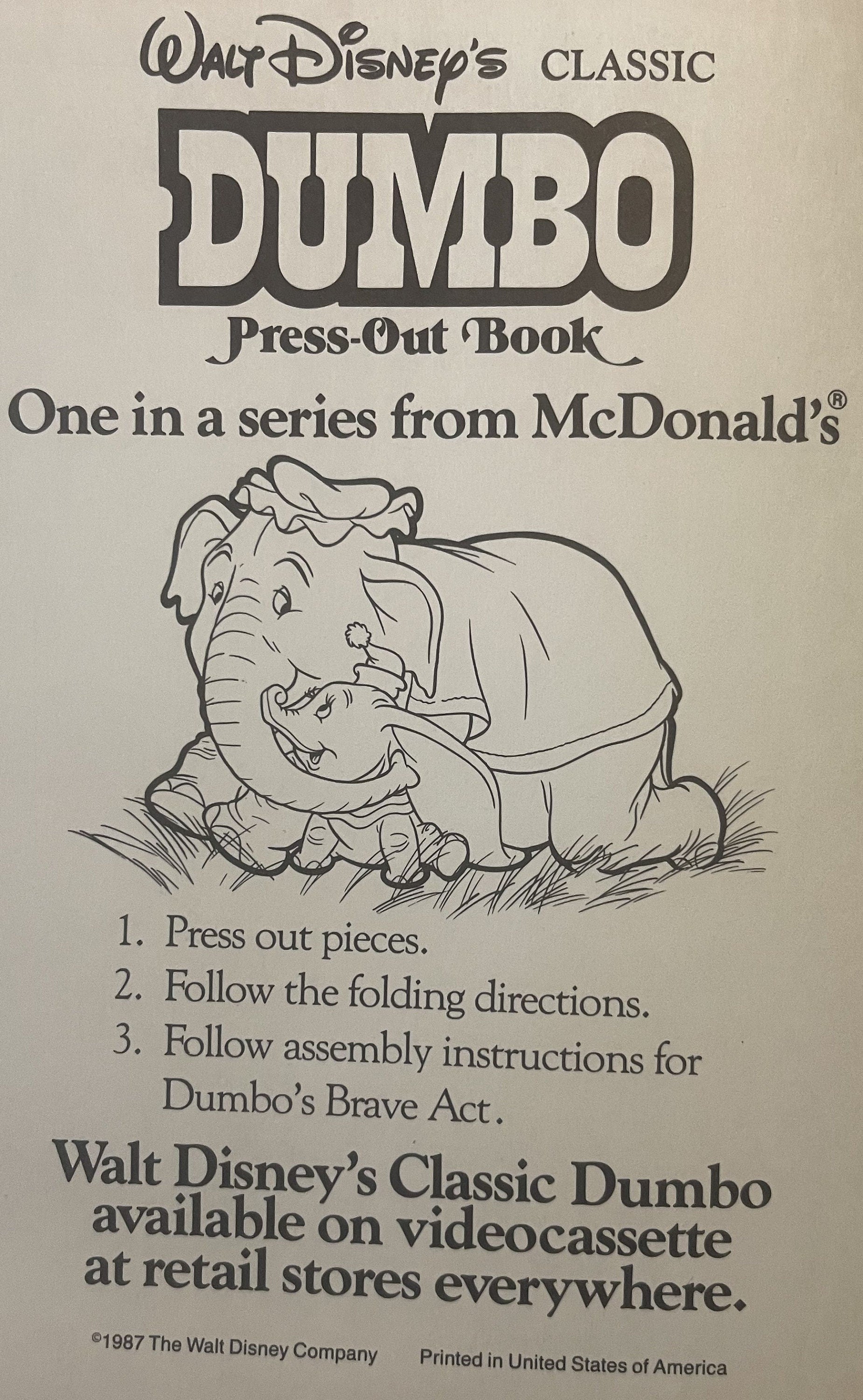 Cover of vintage 1987 Disney Dumbo press-out book from McDonald's, featuring illustrated Dumbo and baby elephant on cream bac