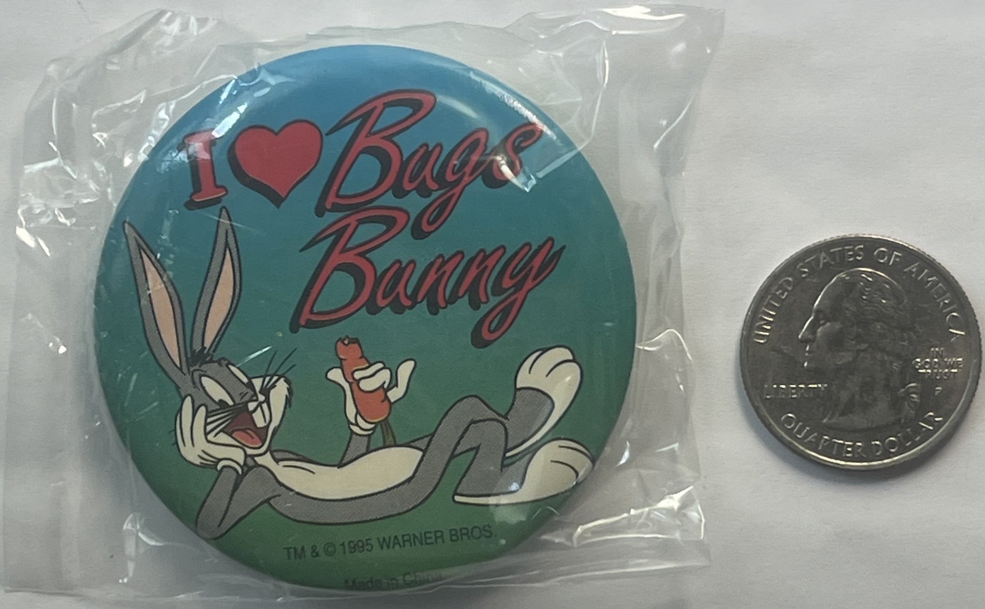 Sealed plastic package containing round pin with teal background, Bugs Bunny cartoon character, red "I ❤ Bugs Bunny" text, an