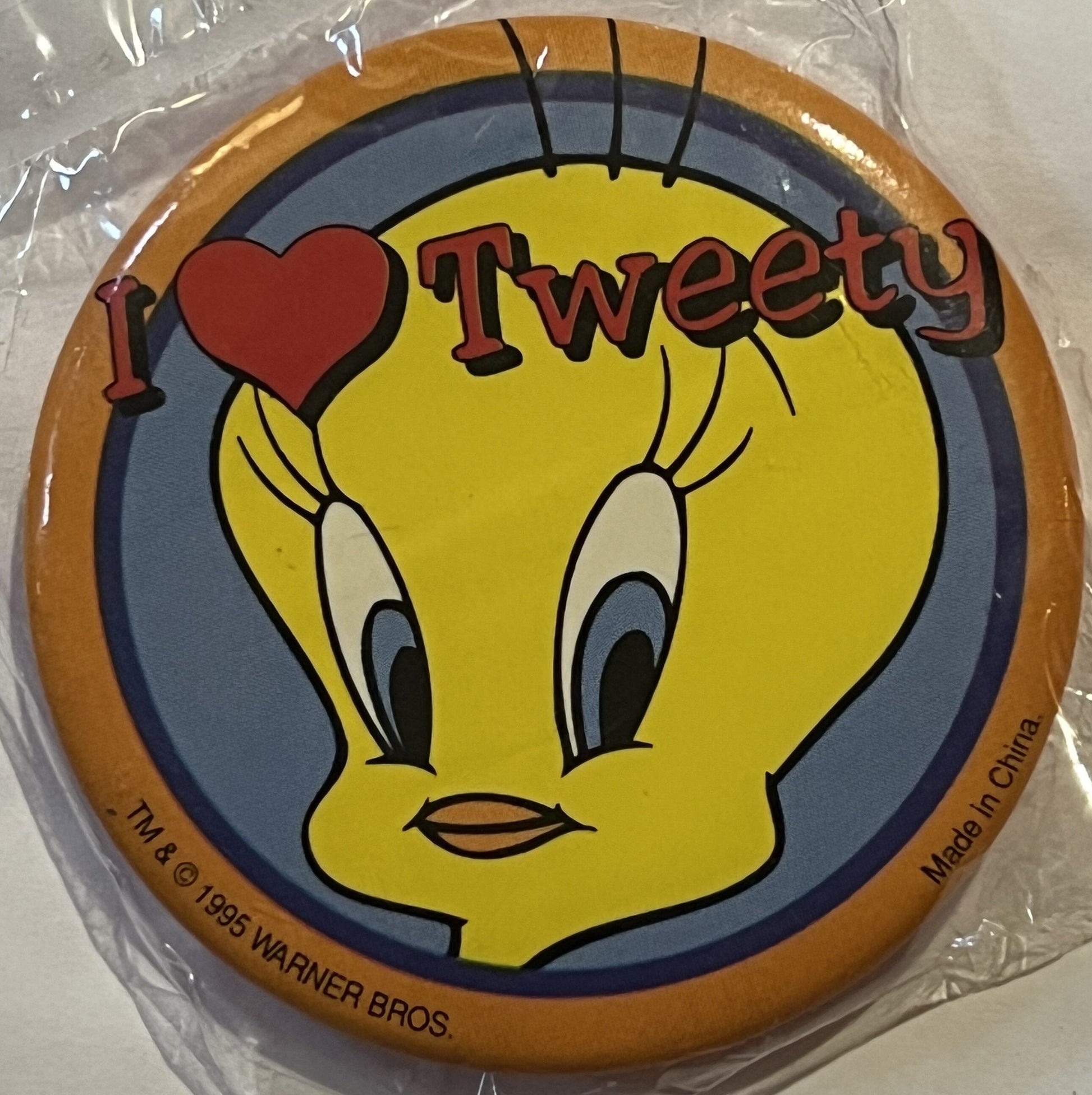 Unopened circular Tweety Bird pin in clear plastic packaging, featuring yellow cartoon bird with "I ❤ Tweety" text and Warner