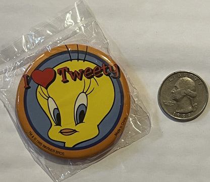 Tweety Bird pin in clear plastic packaging next to a quarter for scale, showing yellow bird with "I love Tweety" text and War