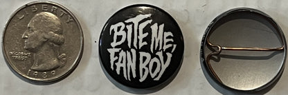 Three views of a vintage pinback button shown next to a quarter for scale: obverse with "LIBERTY" text, reverse with "BITE ME