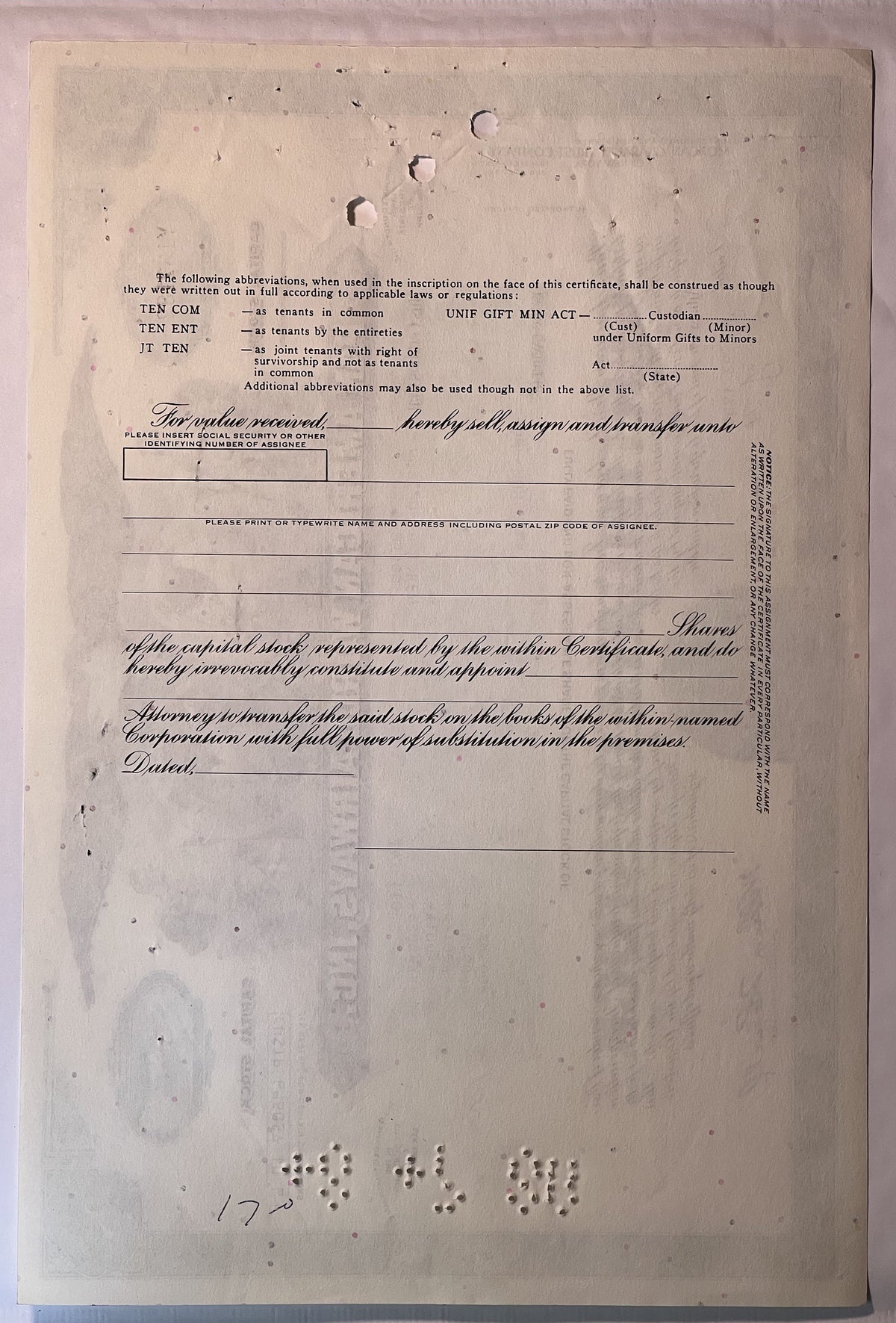 Blank vintage stock certificate form with printed instructions and ornamental script text, aged cream paper with holes and we