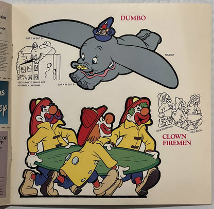 Vintage Disney press-out book page showing Dumbo elephant and three clown firemen characters with assembly instructions and f