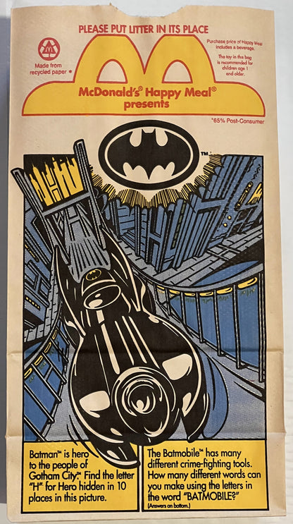 Vintage McDonald's Happy Meal paper bag featuring Batman logo, Batmobile illustration, and activity puzzles on tan recycled p