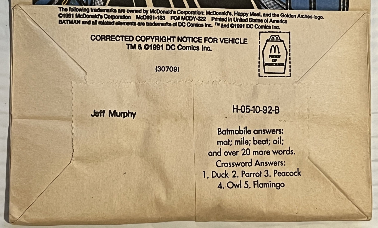 Cream-colored 1991 McDonald's Happy Meal bag back showing Batman copyright notice, crossword answers, and Jeff Murphy's name
