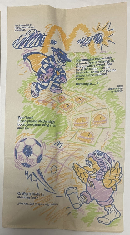 Vintage McDonald's Happy Meal bag interior with Hamburglar, Ronald, and Birdie characters, games, and promotional text in blu