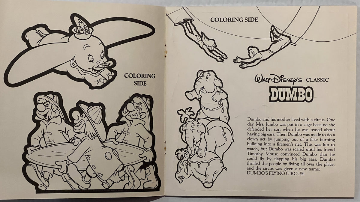 Open vintage Disney Dumbo coloring book showing black line drawings of Dumbo with his mother and circus characters, with stor