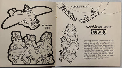 Open vintage Disney Dumbo coloring book showing black line drawings of Dumbo with his mother and circus characters, with stor