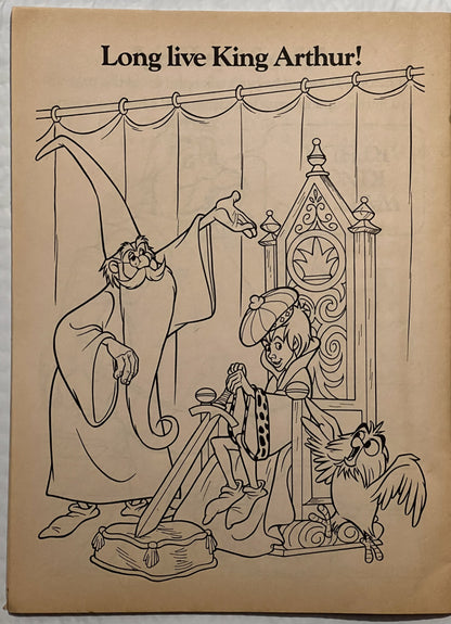 Beige book page with "Long live King Arthur!" headline and black line drawing of cartoon characters including a wizard, knigh