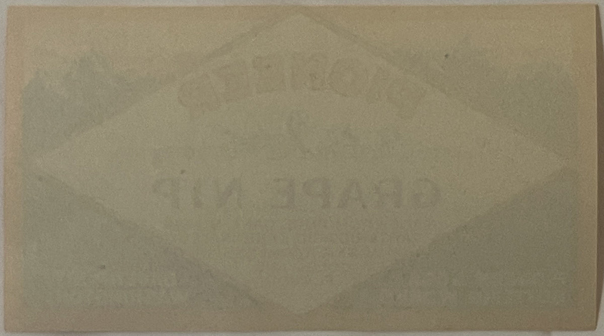Blank cream-colored vintage label or paper document on tan background, heavily aged with visible discoloration and wear marks