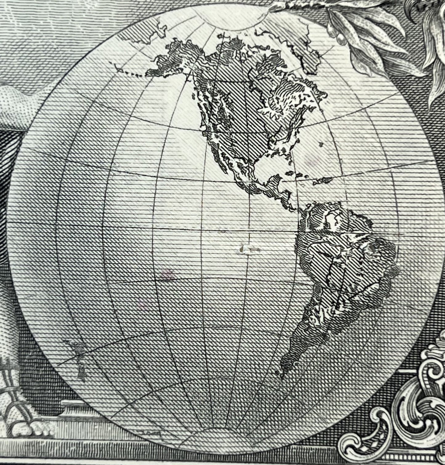 Black and white engraved map of North America centered in oval frame with latitude/longitude grid lines, ornamental scrollwor