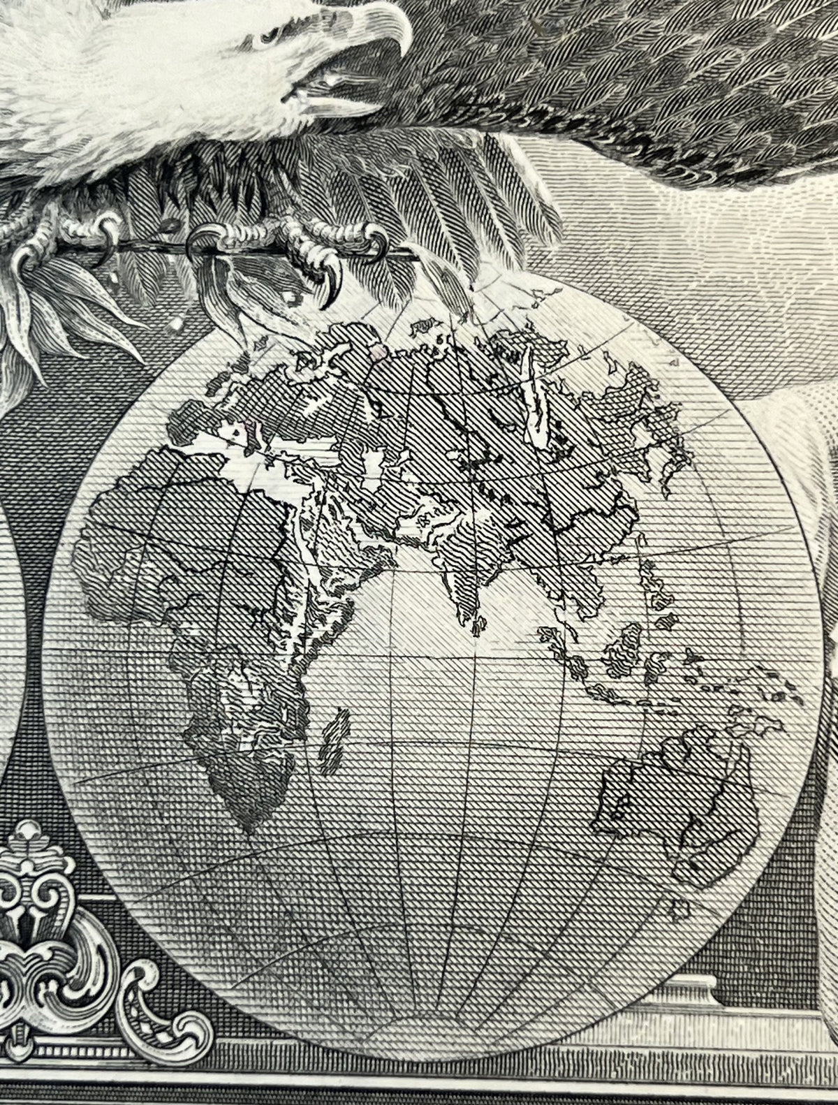 Black and white engraved stock certificate detail showing globe with continents and latitude lines, held by an eagle, ornate 