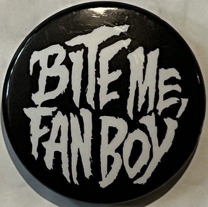 Black circular pinback button with white distressed lettering reading "BITE ME FAN BOY" against light background