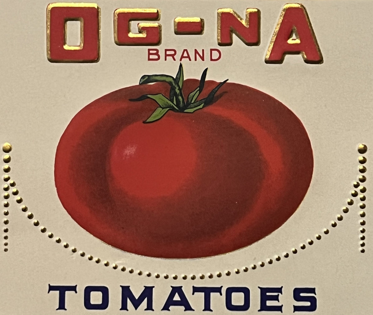 Vintage OG-NA Brand tomato can label with gold-embossed red letters, large red tomato illustration, and dark blue text on cre