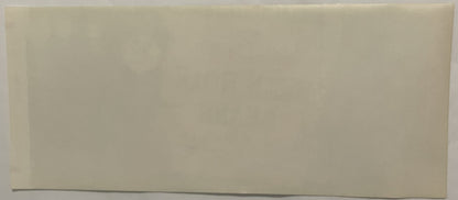 Blank cream-colored vintage label with dark line at bottom edge, photographed against gray surface