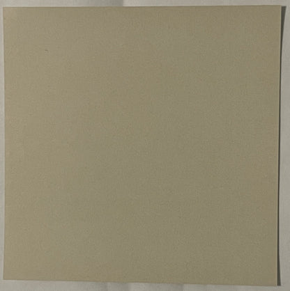 Blank tan cardboard or paper surface with a vertical crease on the right edge, photographed flat