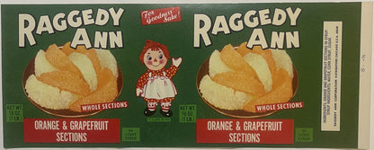 Vintage Raggedy Ann canned fruit label featuring whole orange and grapefruit sections in light syrup, with red-haired doll ch