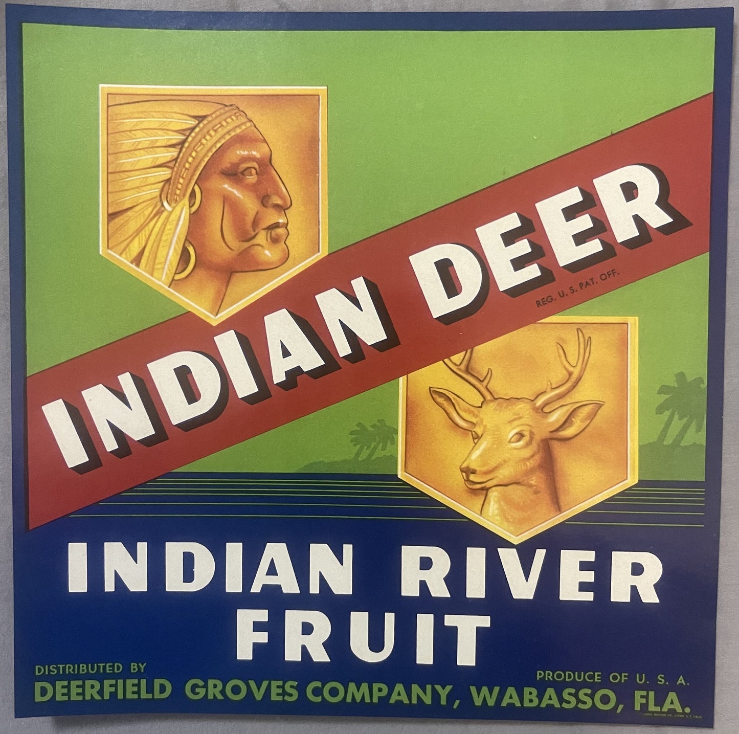 Vintage fruit crate label featuring Native American chief and deer head on green and blue background with red diagonal banner