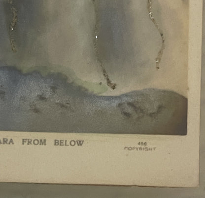 Aged postcard corner showing "FROM BELOW" text and copyright mark, with water-stained vintage photograph of Niagara Falls abo