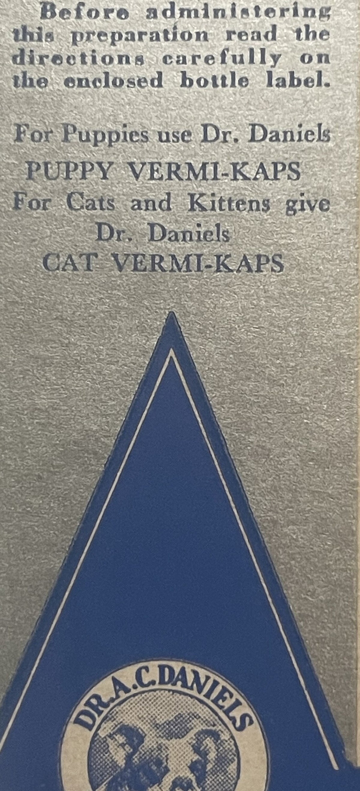 Close-up of vintage blue triangular medicine box label with Dr. A.C. Daniels circular logo and printed text for Puppy and Cat