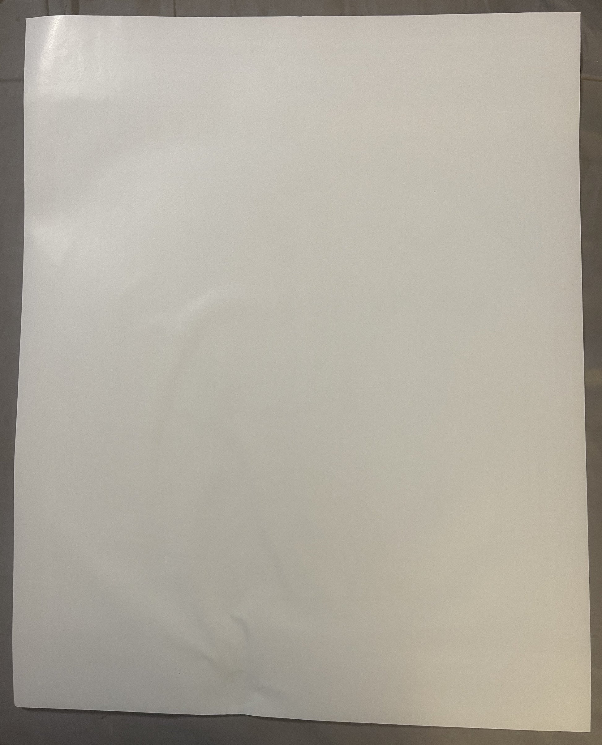 Blank cream-colored poster page photographed flat against gray background, showing slight wrinkles and aging marks