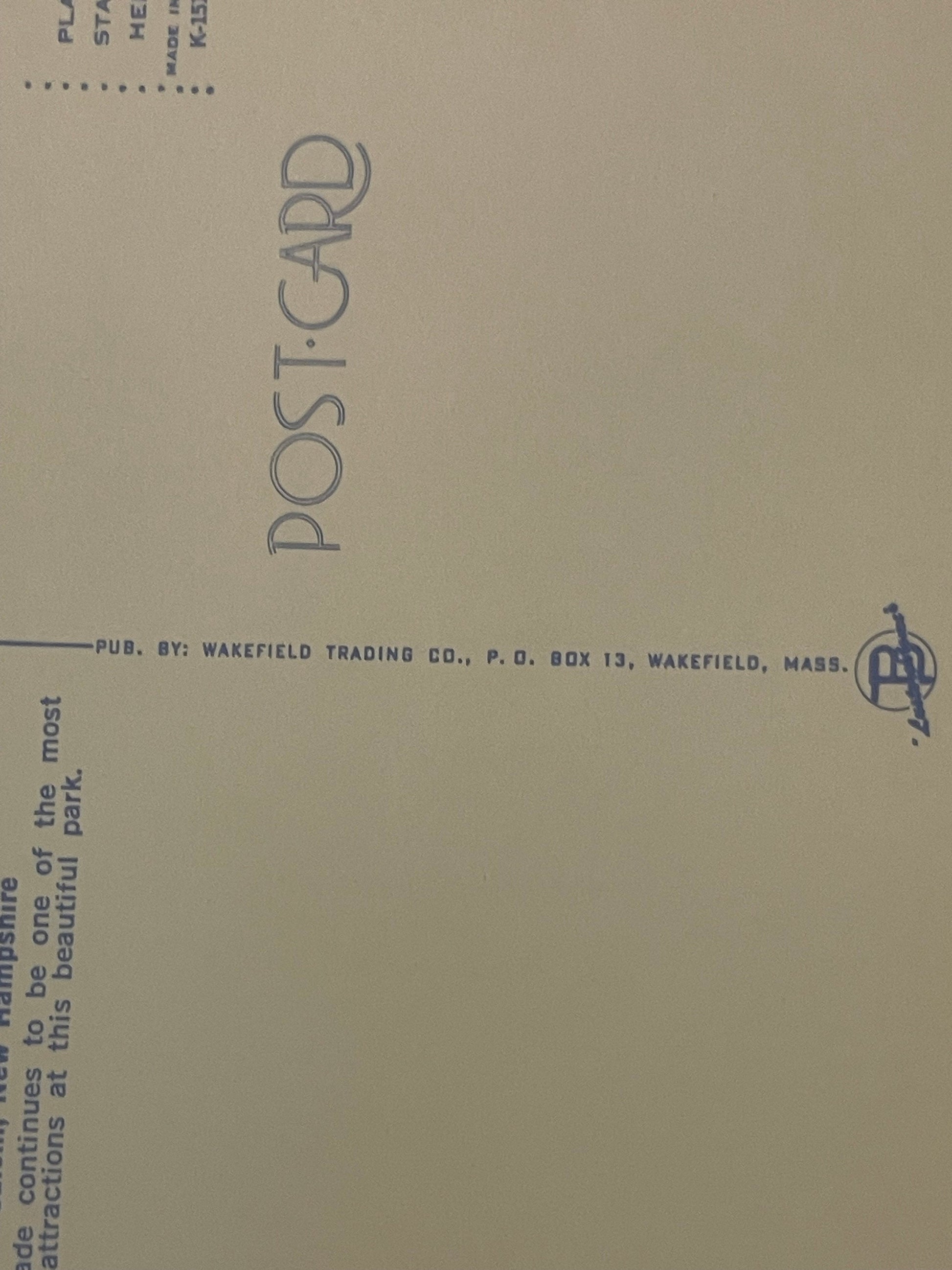 Back of vintage postcard showing "Postcard" text vertically, publisher info for Wakefield Trading Co., and partial text about