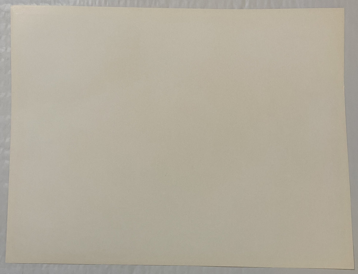 Blank cream-colored page or print surface photographed flat against gray textured background