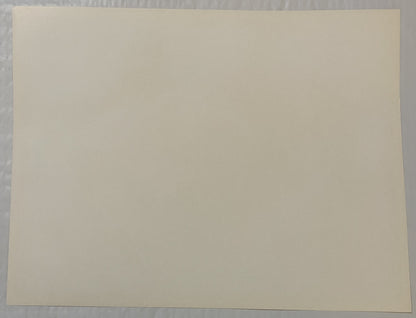 Blank cream-colored page or print surface photographed flat against gray textured background