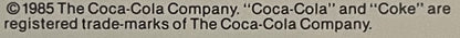 Close-up of copyright notice text from 1985 Coca-Cola Company stating "Coca-Cola" and "Coke" are registered