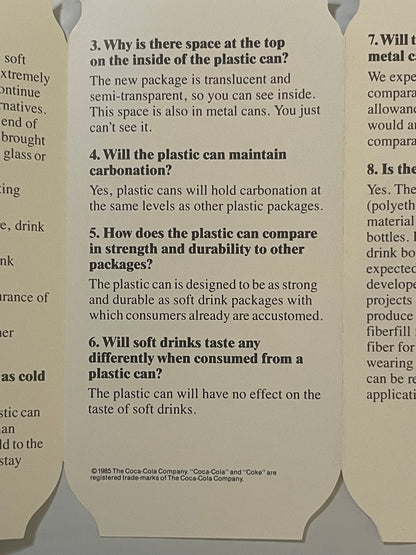 Vintage 1985 Coca-Cola plastic can pamphlet FAQ page with die-cut bottle shapes, tan background, bold black