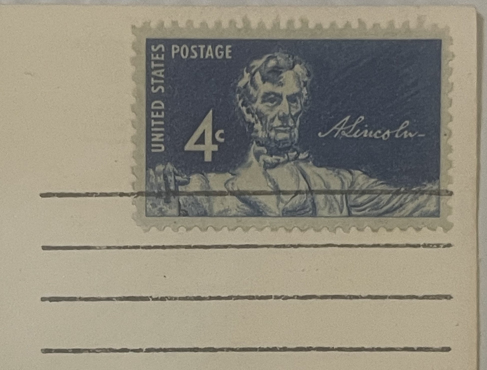Vintage 4-cent postage envelope featuring embossed portrait of Lincoln with signature, unused with blank lines below