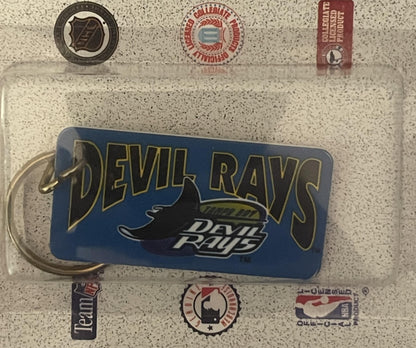 Vintage 1990s Tampa Bay Devil Rays blue keychain with manta ray logo, surrounded by MLB and team logos on textured background