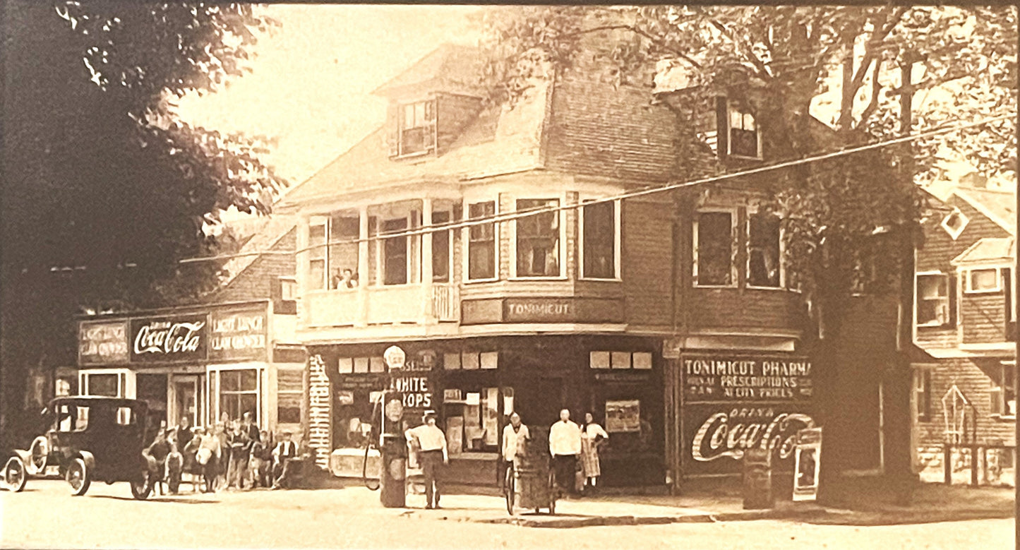 Sepia-toned vintage street scene showing storefront with "White Tops" and "Tonimicut Pharmacy" signs, Coca-Cola advertising, 