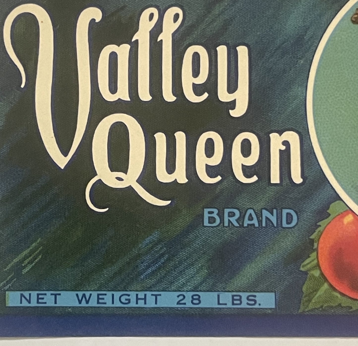 Vintage Valley Queen Brand fruit crate label with cream text on dark teal background, showing red grapes and green leaves, ma