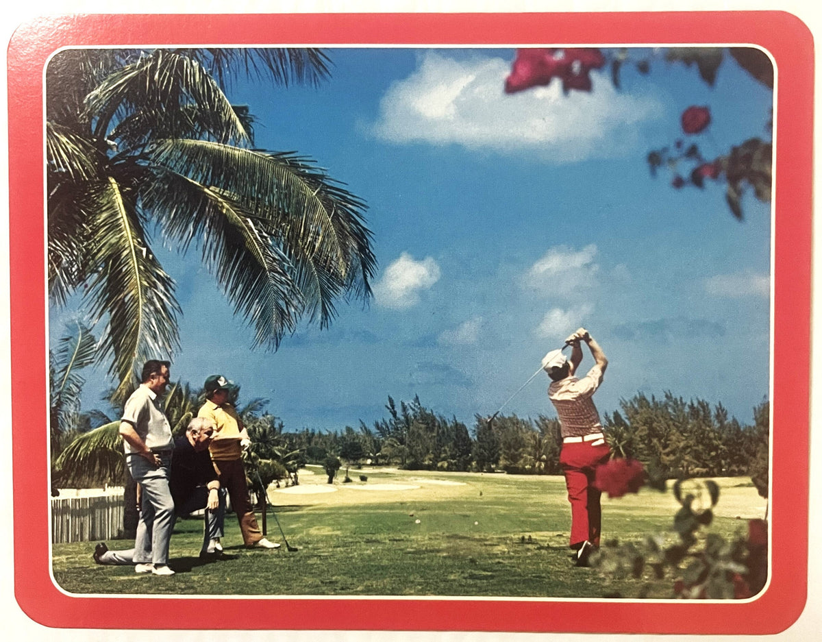 Vintage golf postcard with red border showing golfer mid-swing in tropical setting with palm tree, spectators, and pine trees