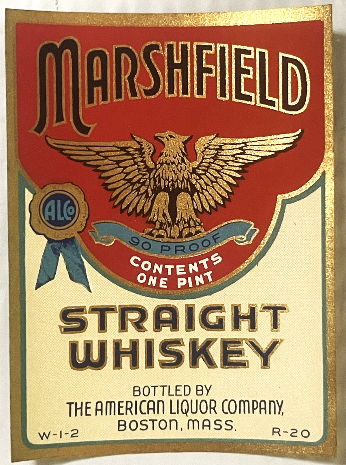 Vintage Marshfield Straight Whiskey label with gold eagle, red and cream background, 90 proof, one pint, bottled by American 