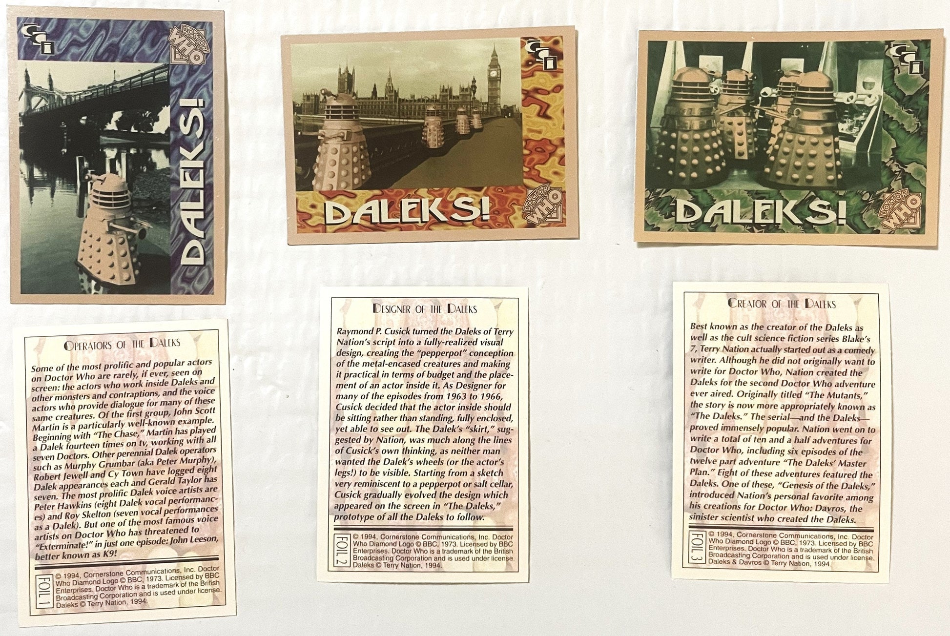 Three vintage 1994 Doctor Who Daleks foil trading cards with colored borders showing Daleks in London scenes, accompanied by 