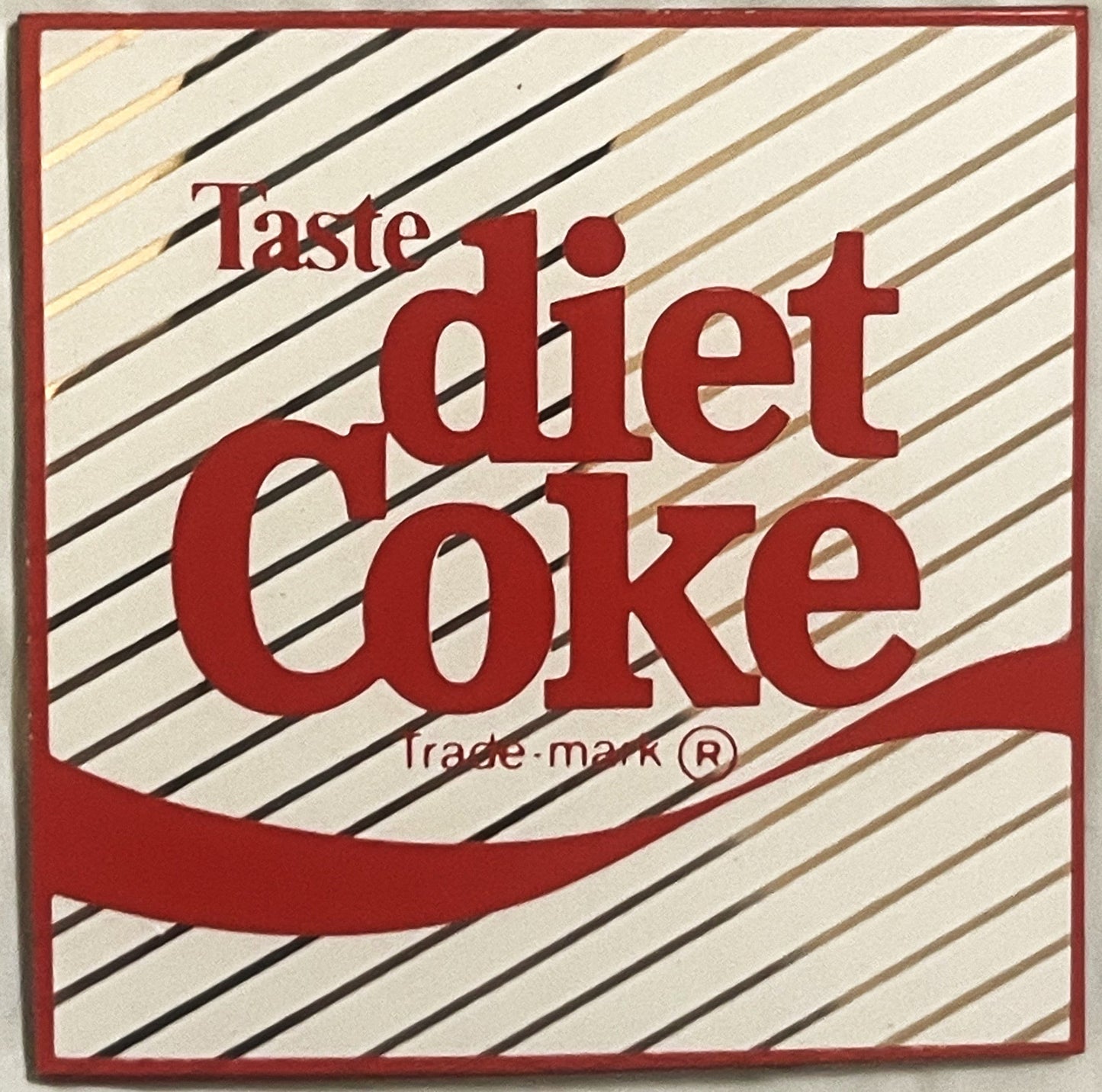 Vintage Diet Coke refrigerator magnet with red text on cream diagonal striped background, trademark symbol visible below